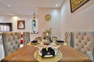 a dining room with a wooden table and chairs at Dar Kech Luxury et comfort in Marrakech