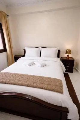 a bedroom with a large bed with white sheets at Bel Appart 2 chambres à 10 min à pied de RAK in Marrakech