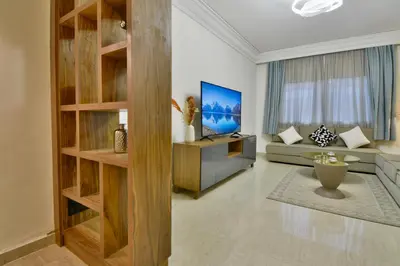 a living room with a couch and a tv at L'adresse- Appartement 4p au centre de Marrakech in Marrakech