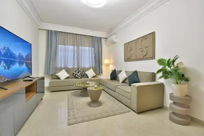 a living room with a couch and a tv at L'adresse- Appartement 4p au centre de Marrakech in Marrakech