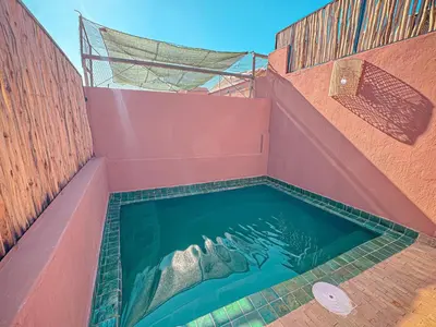a hot tub in a pink building with water in it at Riad Louzaia, Marrakech in Marrakech