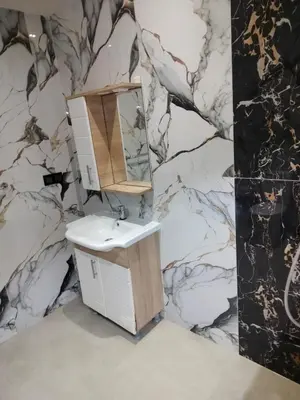 a bathroom with a sink and a mirror on a marble wall at house mohamed in Marrakech