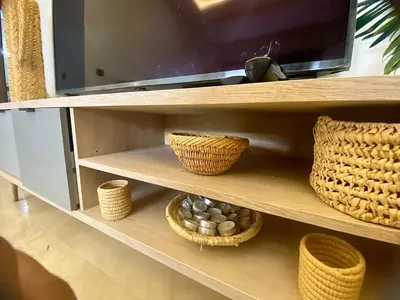 a shelf with baskets and a television on it at Appartement 2 chambres à Gueliz avec piscine Emplacement parfait in Marrakech