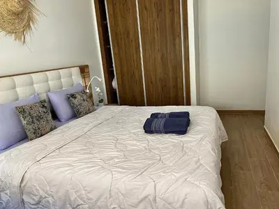 a bedroom with a large white bed with blue pillows at Appartement 2 chambres à Gueliz avec piscine Emplacement parfait in Marrakech