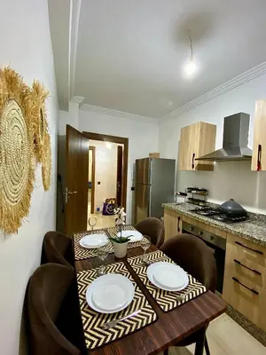 a kitchen with a table with plates on it at Appartement 2 chambres à Gueliz avec piscine Emplacement parfait in Marrakech