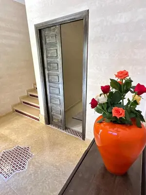 an orange vase with flowers in front of a mirror at flat in Marrakech in Marrakech
