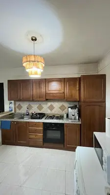 a kitchen with wooden cabinets and a stove top oven at Secure luxury apartment in Marrakech