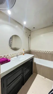 a bathroom with a sink and a tub and a mirror at Secure luxury apartment in Marrakech