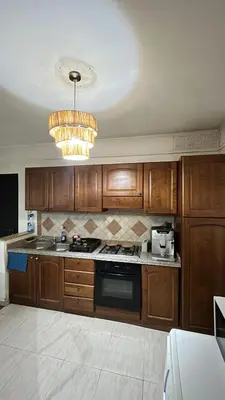 a kitchen with wooden cabinets and a chandelier at Secure luxury apartment in Marrakech