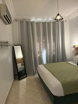 a bedroom with a bed and a mirror and curtains at the wonder of Marrakesh in Marrakech