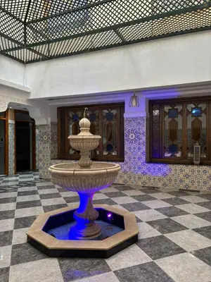 a fountain in a room with a tiled floor at Un appartement au rez-de-chaussée dans une maison in Marrakech