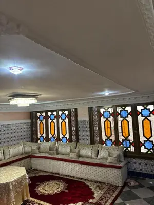 a living room with a couch and stained glass windows at Un appartement au rez-de-chaussée dans une maison in Marrakech