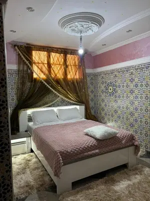 a bedroom with a bed and a chandelier at Un appartement au rez-de-chaussée dans une maison in Marrakech