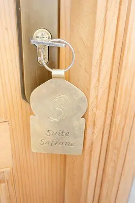 a metal door tag on a wooden door at Riad el fassi & spa charme authentique piscine chauffée in Marrakech