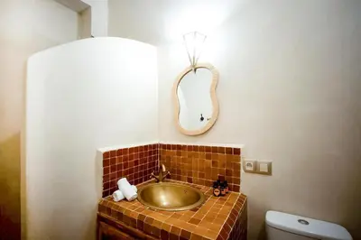 a bathroom with a gold sink and a mirror at Riad el fassi & spa charme authentique piscine chauffée in Marrakech