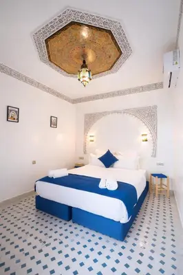 a bedroom with a blue and white bed in a room at Riad el fassi & spa charme authentique piscine chauffée in Marrakech