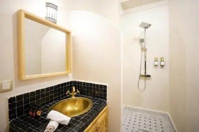a bathroom with a gold sink and a mirror at Riad el fassi & spa charme authentique piscine chauffée in Marrakech