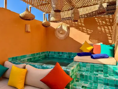 a swimming pool with pillows sitting next to a room with at Kasbahbibi pool breakfast city center private in Marrakech
