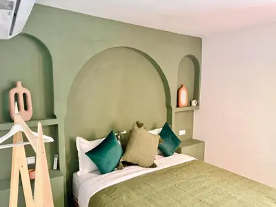 a bedroom with a bed with an arched headboard at Kasbahbibi pool breakfast city center private in Marrakech