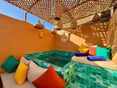 a hot tub in a room with colorful pillows at Kasbahbibi pool breakfast city center private in Marrakech