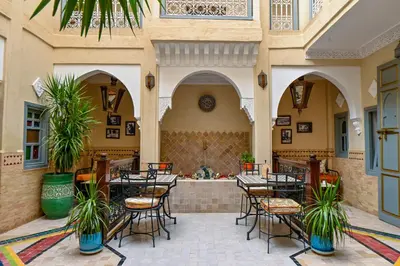 a restaurant with tables and chairs in a building at Riad Matins De Marrakech in Marrakech