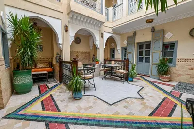 a courtyard with tables and chairs in a building at Riad Matins De Marrakech in Marrakech