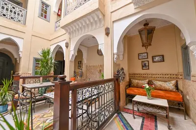 a balcony with a couch and tables in a building at Riad Matins De Marrakech in Marrakech