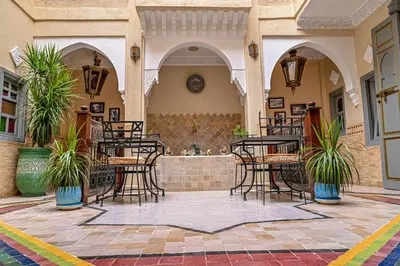 a patio with chairs and tables in a building at Riad Matins De Marrakech in Marrakech