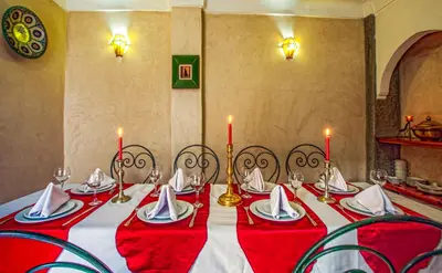a red and white table with chairs and candles at Riad Matins De Marrakech in Marrakech