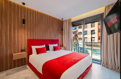 a red and white bed in a room with a window at Confort Haut de Gamme au Coeur de la Ville in Marrakech