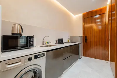 a kitchen with a washing machine and a sink at Confort Haut de Gamme au Coeur de la Ville in Marrakech