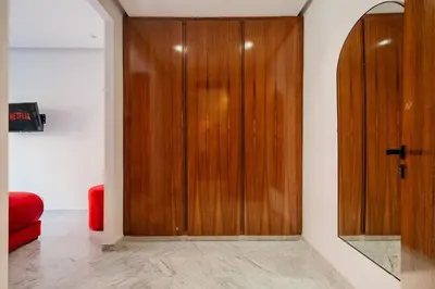 a wooden door in a room with a red couch at Confort Haut de Gamme au Coeur de la Ville in Marrakech