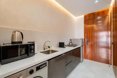 a kitchen with a sink and a microwave at Confort Haut de Gamme au Coeur de la Ville in Marrakech