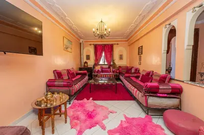 a living room with pink furniture and a chandelier at DarSaouiri55 in Marrakech