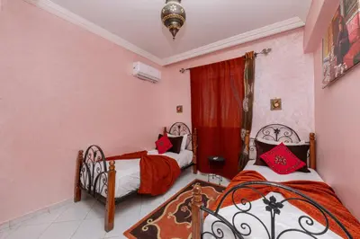 a bedroom with two beds and a window at DarSaouiri55 in Marrakech