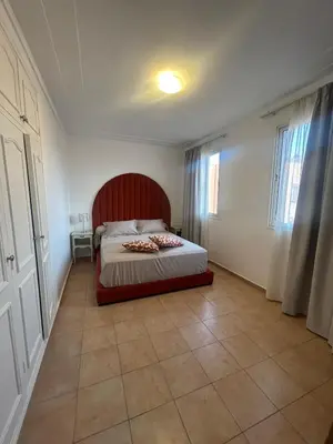 a bedroom with a bed with a red headboard at Appartement 3 Chambres 140 m Najd, Calme & Confort in Marrakech