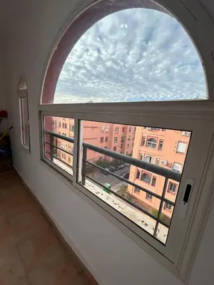 an arched window with a view of a building at Appartement 3 Chambres 140 m Najd, Calme & Confort in Marrakech