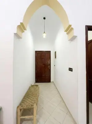 a hallway with a bench in front of a door at Stylish Magnifique Duplex de Standing, 3 Chambres, Piscine, Proche de Gueliz in Marrakech