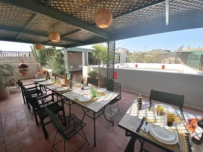 a patio with tables and chairs on a roof at Riad 191 - Maison privée, spa & piscine in Marrakech
