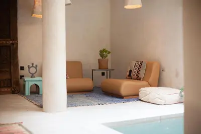 a living room with two chairs and a pool at Dar Alma Modernist Designer Riad with Pool in Marrakech