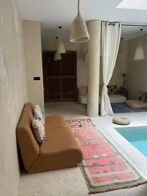 a living room with a couch next to a swimming pool at Dar Alma Modernist Designer Riad with Pool in Marrakech