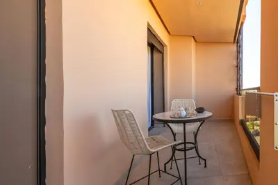 a small table and chairs in a small balcony at grand studio hypercentre de marrakech et proche gare in Marrakech