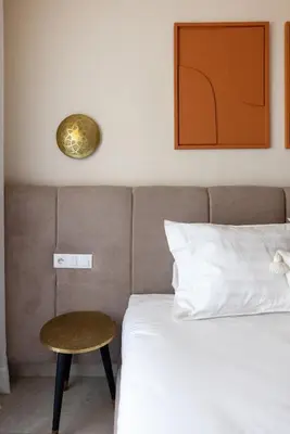 a bedroom with a bed with a stool next to it at grand studio hypercentre de marrakech et proche gare in Marrakech