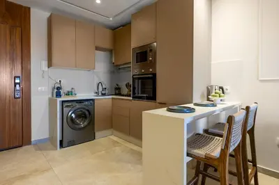 a kitchen with a washer and dryer next to a counter at grand studio hypercentre de marrakech et proche gare in Marrakech