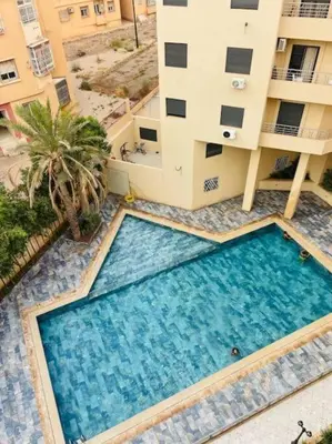 an overhead view of a swimming pool in front of a building at Appartement luxueux au centre in Marrakech