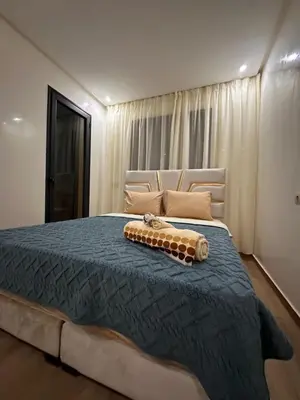a bedroom with a large bed with a blue comforter at Appartement luxueux au centre in Marrakech
