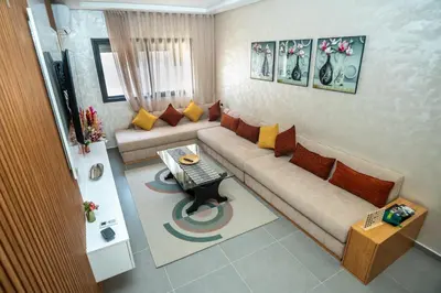a living room with a couch and a table at Oasis Urban avec Balcon - 5min de l'aéroport in Marrakech