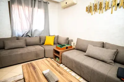 a living room with a couch and a table at Haven Cosy avec Piscine in Marrakech