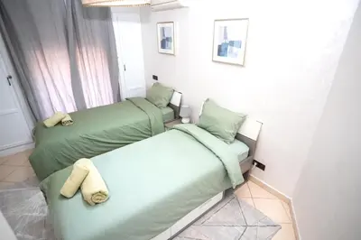 two beds in a room with green sheets at Haven Cosy avec Piscine in Marrakech