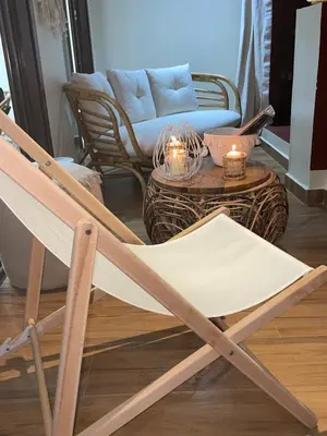 a wooden rocking chair in a living room with a couch at Appartement moderne terrasse avec baignoire privée in Marrakech